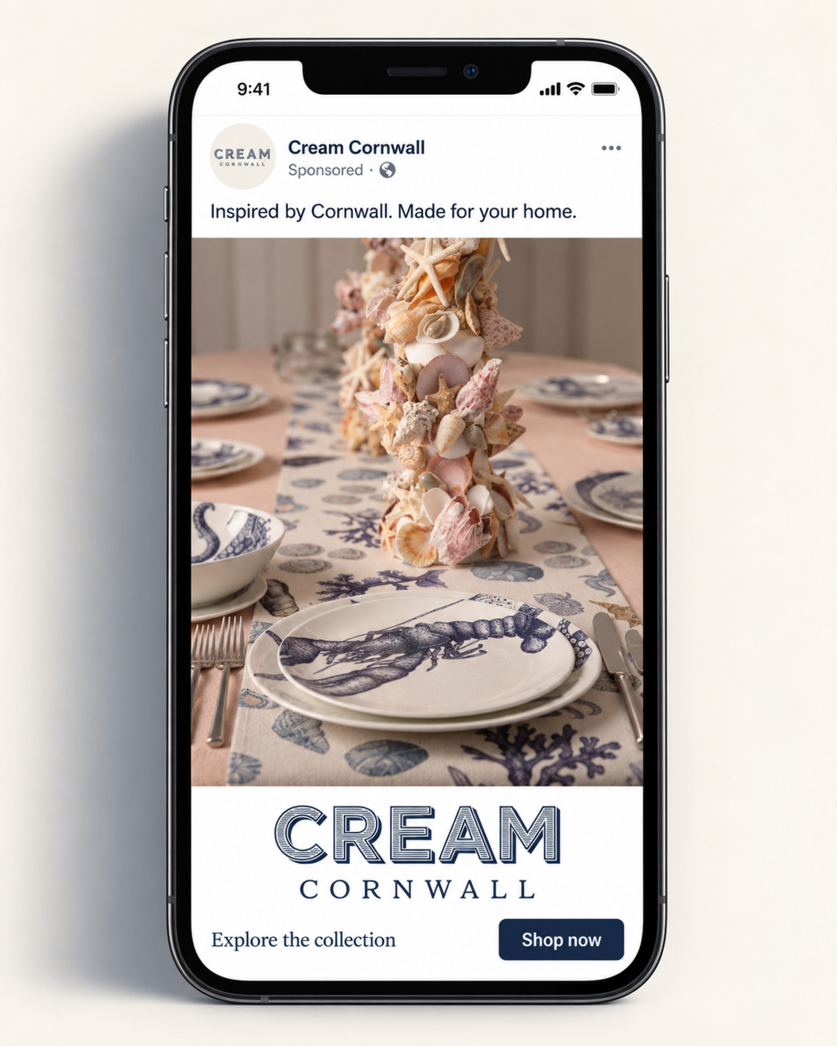 Illustrative layout of a sponsored Cream Cornwall post on a phone, showing a table laid with lobster and shell tableware under the line Inspired by Cornwall. Made for your home, with a Shop now button. Suggested copy, not an original campaign screenshot.
