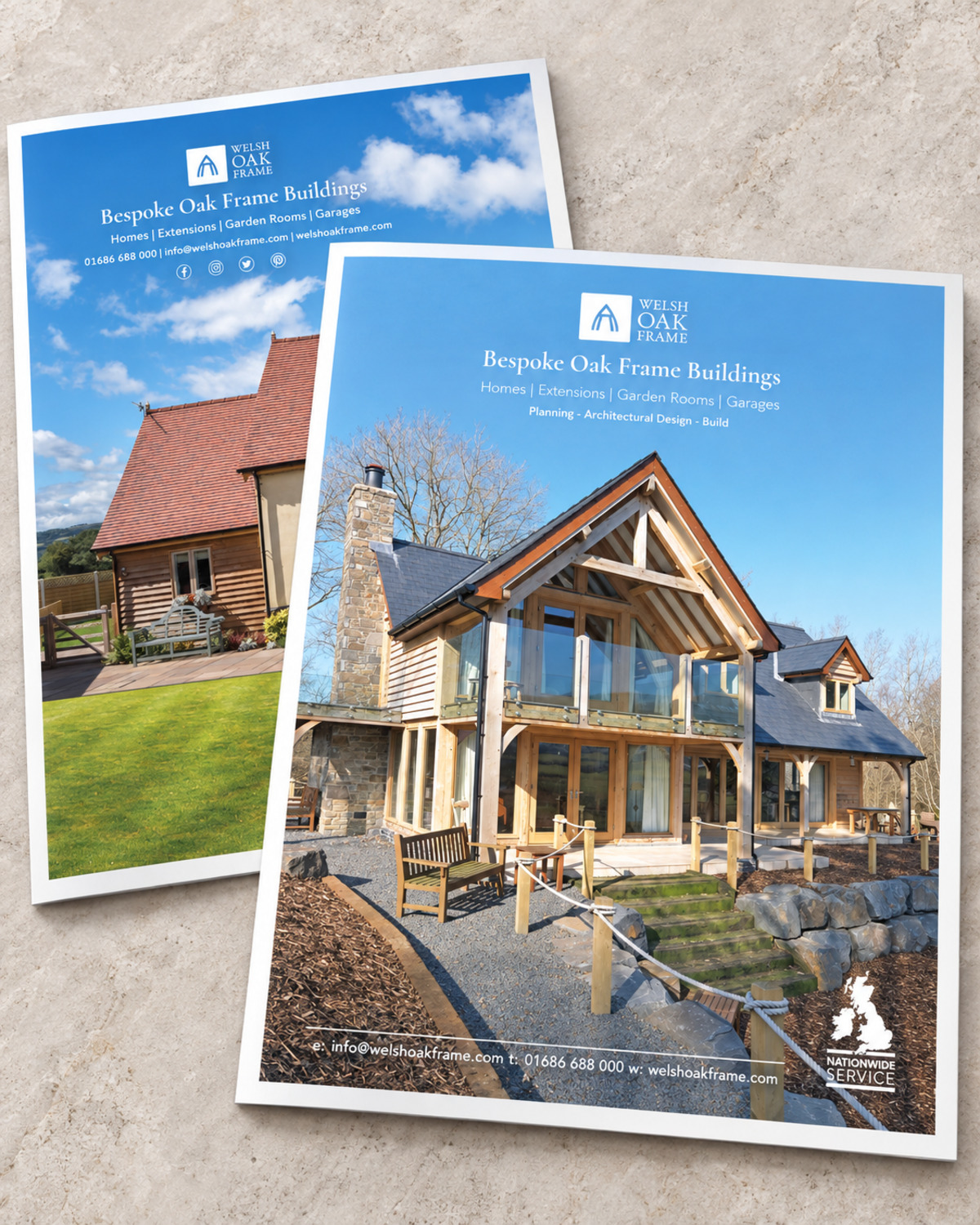 Illustrative layout of two Welsh Oak Frame print advertisements headed Bespoke Oak Frame Buildings, one showing an oak-framed house with a glazed gable and stone chimney, the other an oak garage with a red-tiled roof. Suggested copy, not an original campaign screenshot.