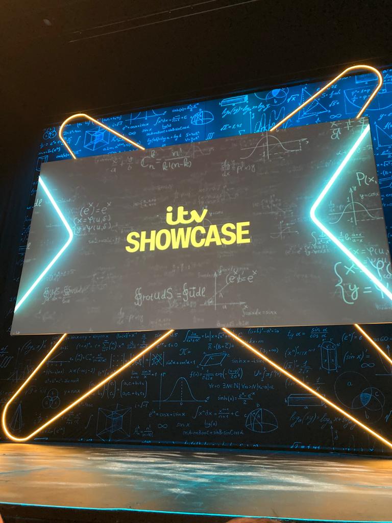 A board illuminated with neon lights displaying the text 'ITV showcase'