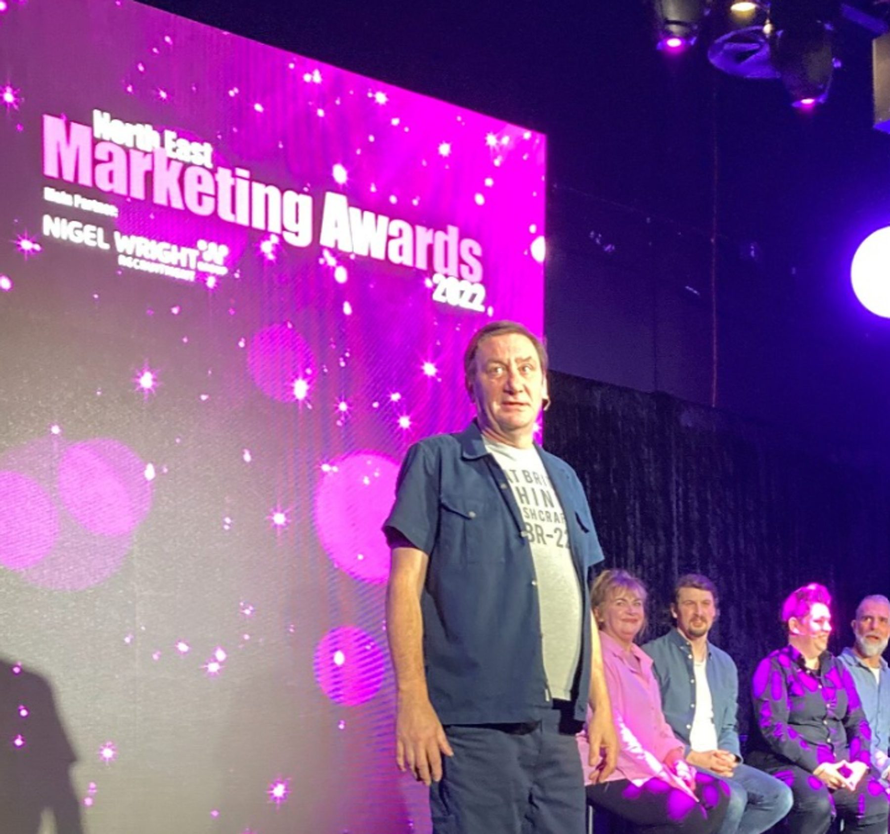 Guests on stage in front of the North East Marketing Awards 2022 screen