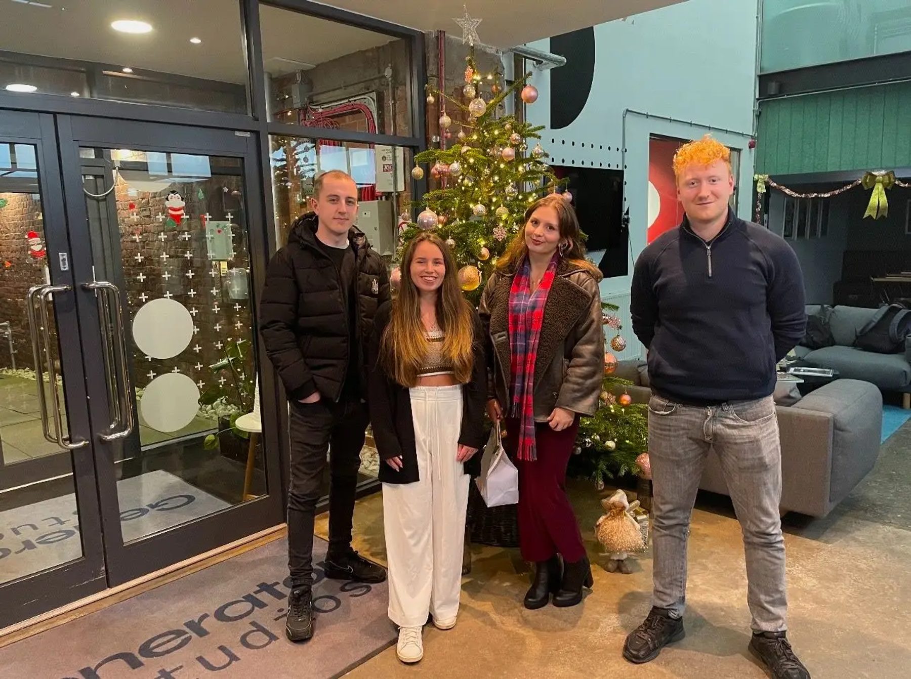 Four Route team members beside the Christmas tree in the Generator Studios reception