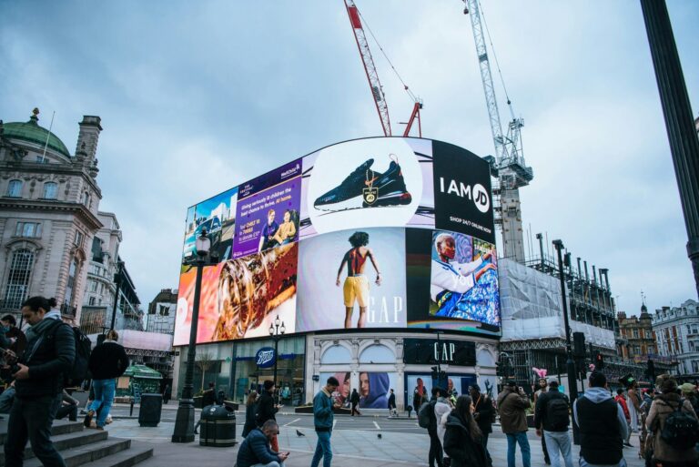 Digital out of home advertising screens at Piccadilly Lights, London, showing several brand campaigns above street level