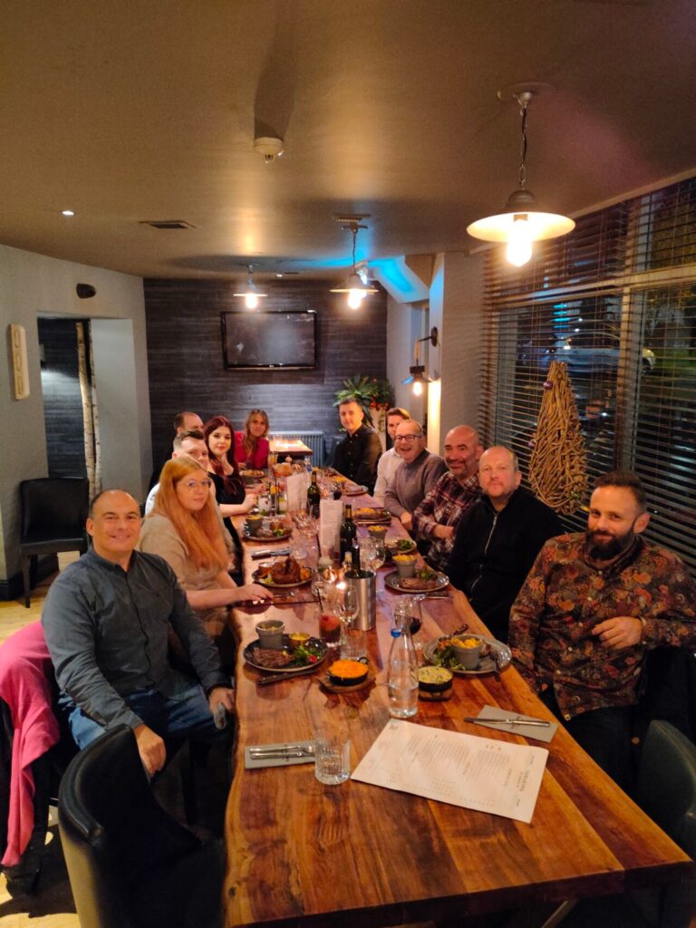 Route Agency team members sitting around a table and celebrating Christmas